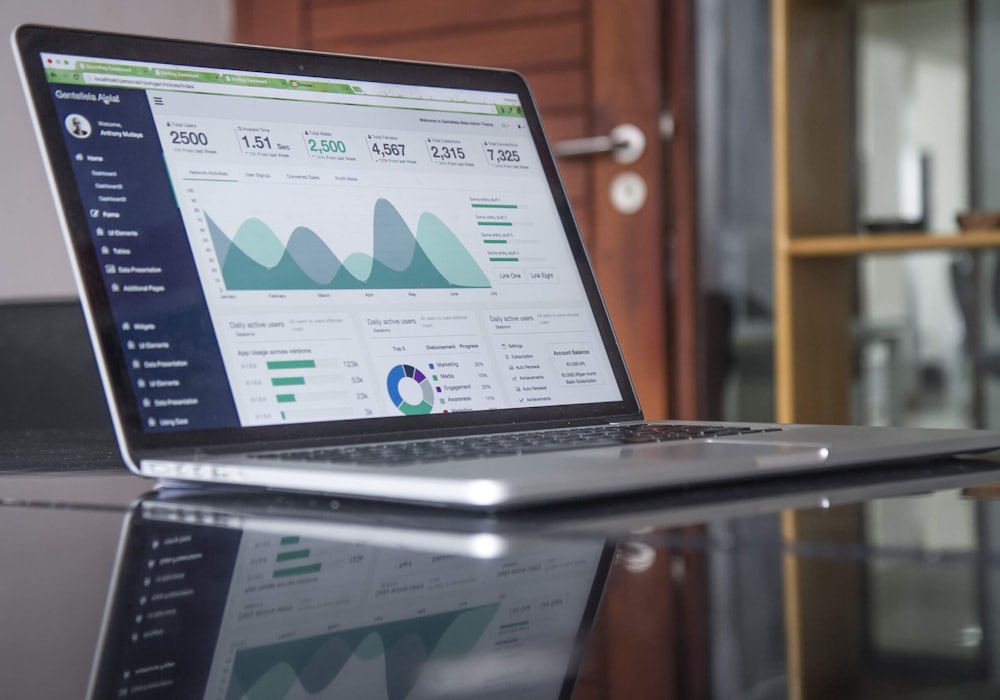 A laptop displaying keyword ranking and traffic analytics charts.