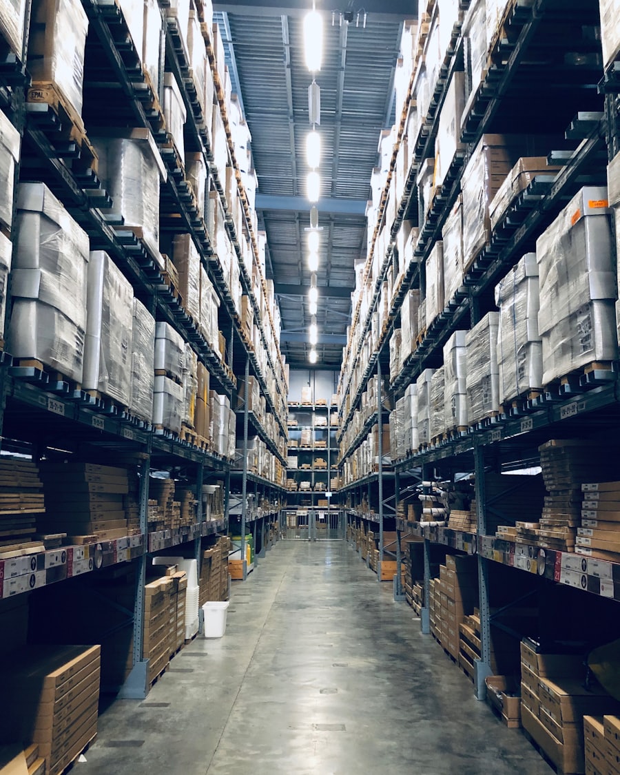 A long aisle of stocked pallet racking inside a fulfilment warehouse.